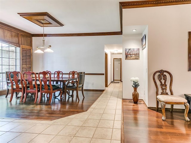dining area with light wood-type flooring, crown molding, and baseboards