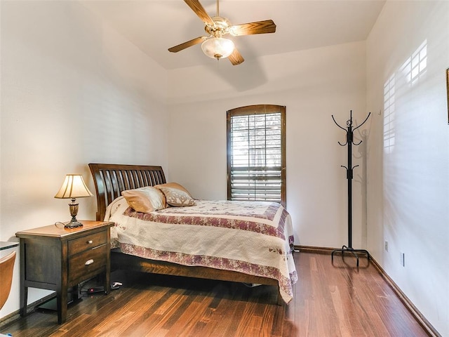 bedroom featuring wood finished floors, ceiling fan, vaulted ceiling, and baseboards