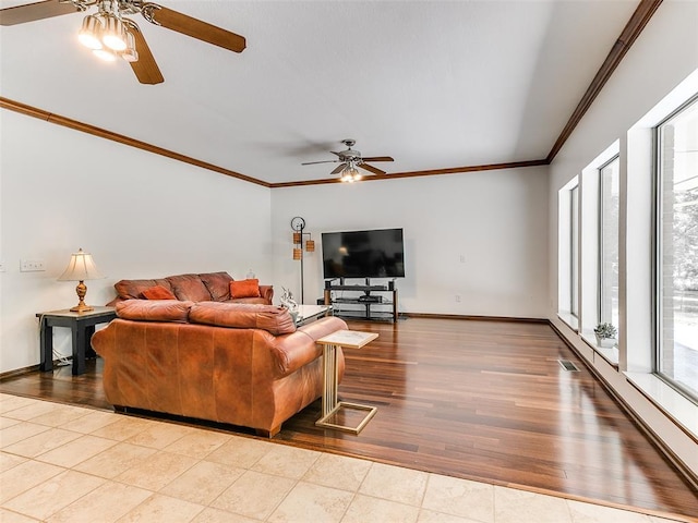 living room with ceiling fan, crown molding, baseboards, and wood finished floors