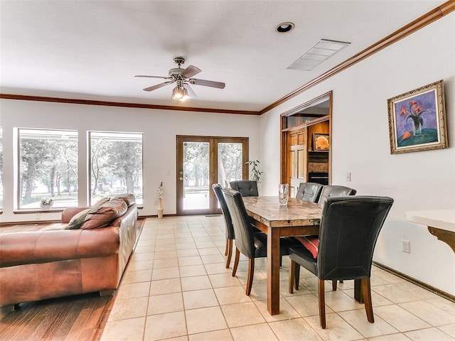 dining space featuring ceiling fan, baseboards, ornamental molding, and light tile patterned flooring