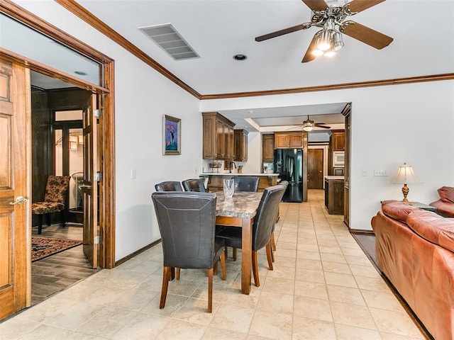 dining room with ceiling fan, ornamental molding, baseboards, and light tile patterned floors