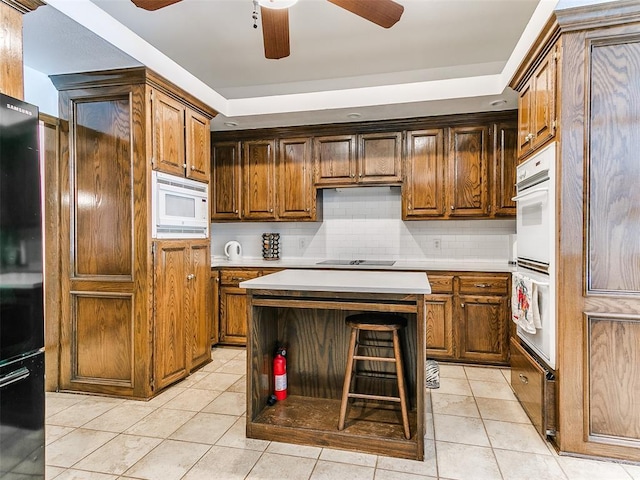 kitchen with black appliances, ceiling fan, light tile patterned floors, and decorative backsplash