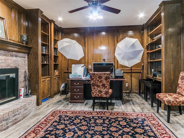 13974 S Broadway St, Edmond, OK 73034 - office area featuring a ceiling fan, light wood-style flooring, a brick fireplace, and wooden walls