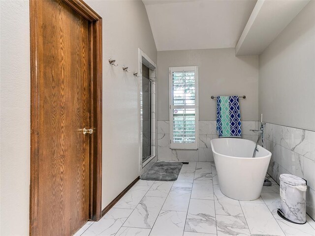 13974 S Broadway St, Edmond, OK 73034 - bathroom with marble look tiles, tile walls, a stall shower, a freestanding bath, and a wainscoted wall