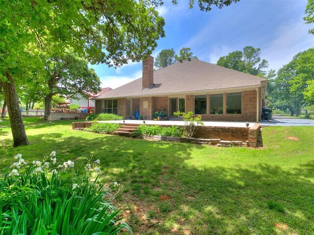 13974 S Broadway St, Edmond, OK 73034 - back of house with a chimney, brick siding, and a shingled roof