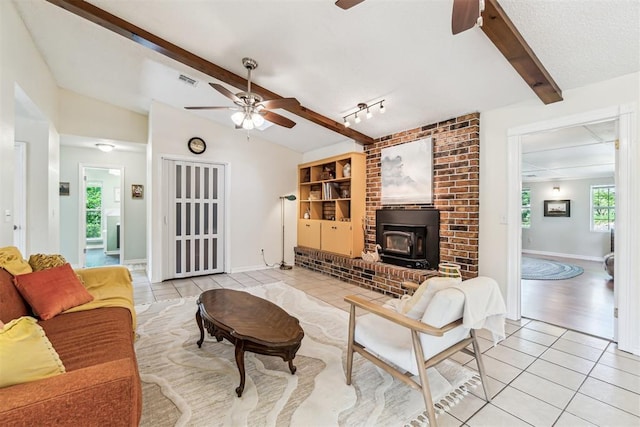 125 Creek Hollow Dr, Choctaw, OK 73020 - living room featuring ceiling fan, a wood stove, light tile patterned floors, and baseboards