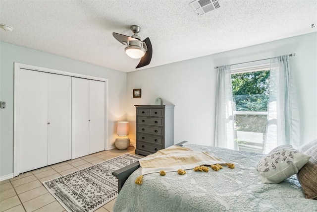 125 Creek Hollow Dr, Choctaw, OK 73020 - bedroom with light tile patterned floors, a closet, ceiling fan, and a textured ceiling
