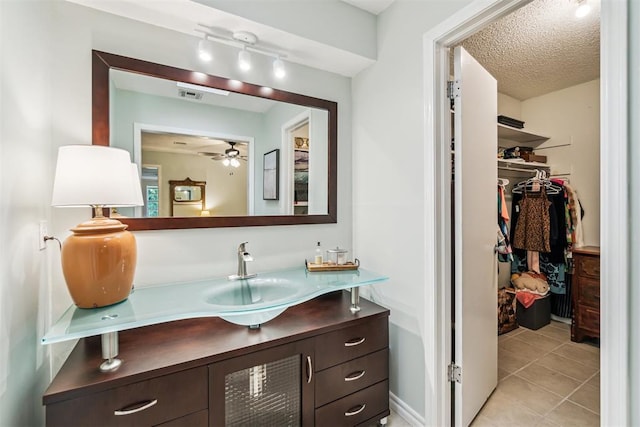 125 Creek Hollow Dr, Choctaw, OK 73020 - bathroom with ceiling fan, vanity, tile patterned flooring, a spacious closet, and a textured ceiling