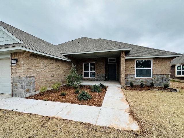 1216 SW 139th St, Oklahoma City, OK 73170 - view of front of house featuring a shingled roof, an attached garage, and stone siding