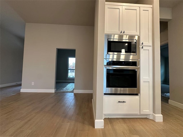 1216 SW 139th St, Oklahoma City, OK 73170 - kitchen featuring appliances with stainless steel finishes, light wood finished floors, white cabinetry, and baseboards