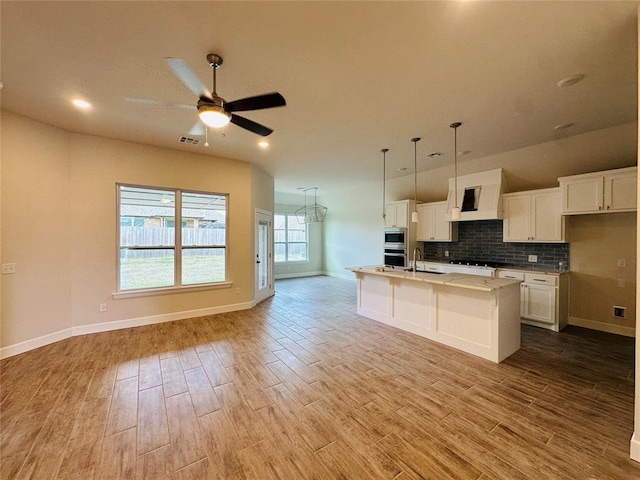 917 SW 141st St, Oklahoma City, OK 73170 - kitchen with light wood-style flooring, open floor plan, white cabinets, and recessed lighting