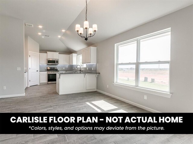 8517 NW 76th St, Oklahoma City, OK 73132 - kitchen featuring stainless steel appliances, a chandelier, white cabinetry, lofted ceiling, and decorative light fixtures