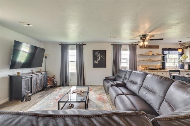 2316 E 68th St, Stillwater, OK 74074 - living area featuring baseboards, light wood-type flooring, and a ceiling fan