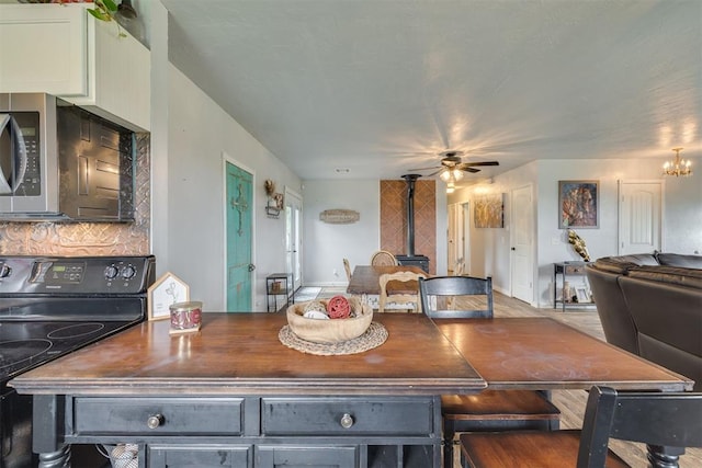2316 E 68th St, Stillwater, OK 74074 - dining room with a wood stove and a ceiling fan