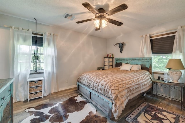 2316 E 68th St, Stillwater, OK 74074 - bedroom with wood finished floors, a textured ceiling, ceiling fan, and baseboards
