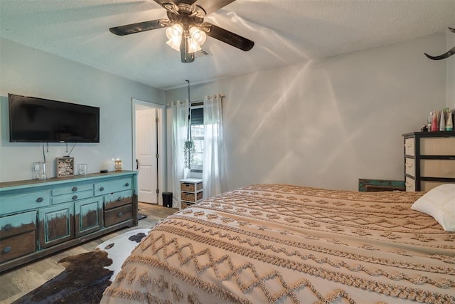 2316 E 68th St, Stillwater, OK 74074 - bedroom with light wood-type flooring, a ceiling fan, and a textured ceiling