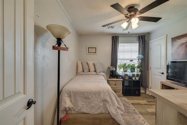2316 E 68th St, Stillwater, OK 74074 - bedroom featuring wood finished floors, a textured ceiling, crown molding, and a ceiling fan