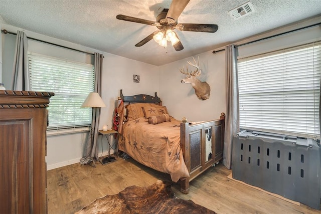 2316 E 68th St, Stillwater, OK 74074 - bedroom featuring wood finished floors, a textured ceiling, and ceiling fan
