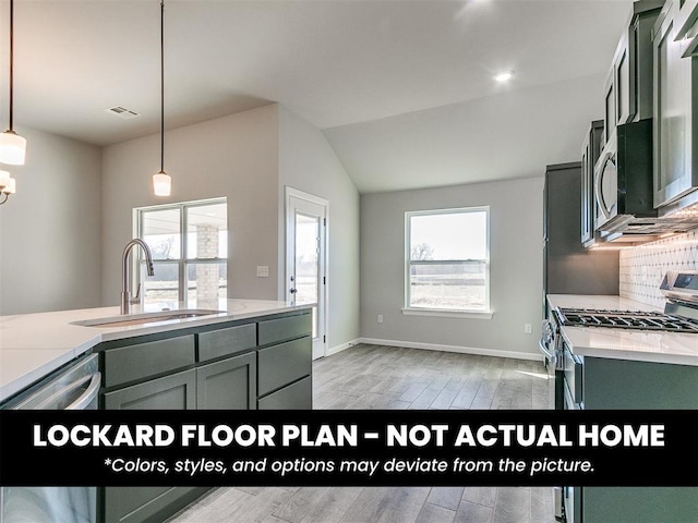 8609 NW 76th St, Oklahoma City, OK 73132 - kitchen featuring a sink, appliances with stainless steel finishes, light wood-type flooring, baseboards, and lofted ceiling