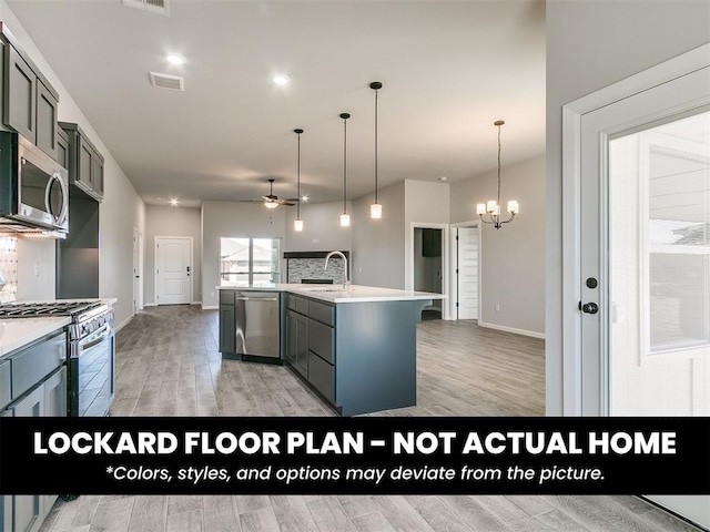 8609 NW 76th St, Oklahoma City, OK 73132 - kitchen featuring appliances with stainless steel finishes, a ceiling fan, a sink, light countertops, and light wood-type flooring