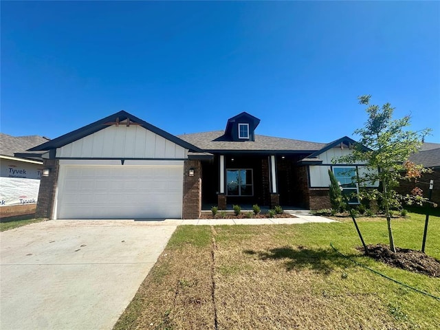 8609 NW 76th St, Oklahoma City, OK 73132 - view of front of home featuring brick siding, a front yard, an attached garage, concrete driveway, and board and batten siding
