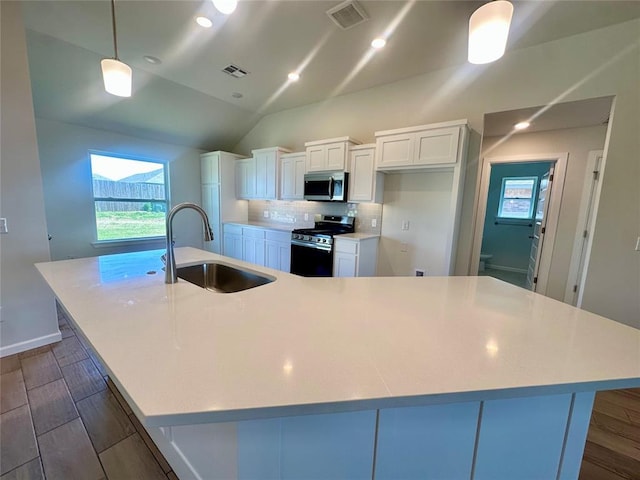 8609 NW 76th St, Oklahoma City, OK 73132 - kitchen with stainless steel appliances, a sink, a spacious island, white cabinets, and plenty of natural light