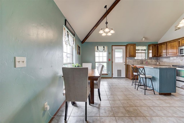 1312 SW 25th St, Moore, OK 73170 - dining space with light tile patterned floors, a chandelier, a textured wall, and baseboards