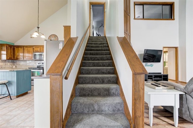 1312 SW 25th St, Moore, OK 73170 - stairs featuring a chandelier, high vaulted ceiling, and baseboards