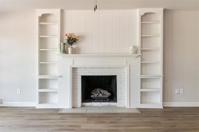2424 Ashley Dr, The Village, OK 73120 - detailed view of wood finished floors, baseboards, and a brick fireplace
