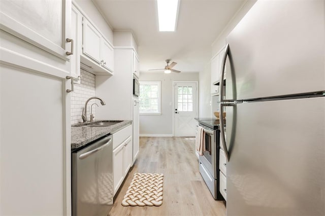 2424 Ashley Dr, The Village, OK 73120 - kitchen with stainless steel appliances, a sink, white cabinetry, tasteful backsplash, and light wood finished floors