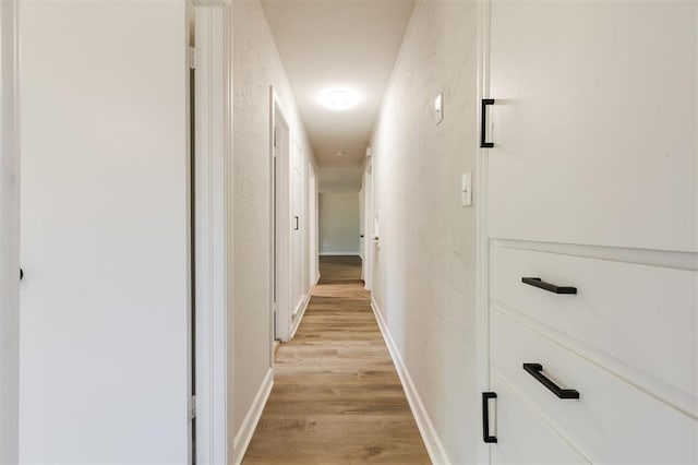 2424 Ashley Dr, The Village, OK 73120 - hall featuring light wood finished floors, a textured wall, and baseboards