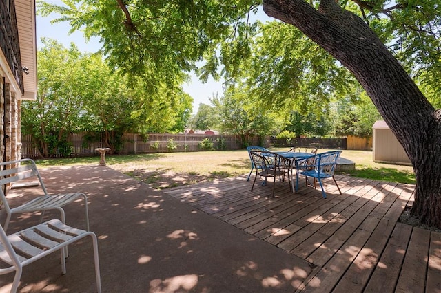 2424 Ashley Dr, The Village, OK 73120 - wooden deck featuring a storage shed, outdoor dining space, and an outbuilding