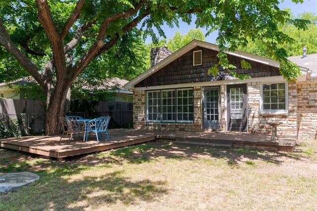 2424 Ashley Dr, The Village, OK 73120 - rear view of house featuring stone siding, a chimney, and a deck