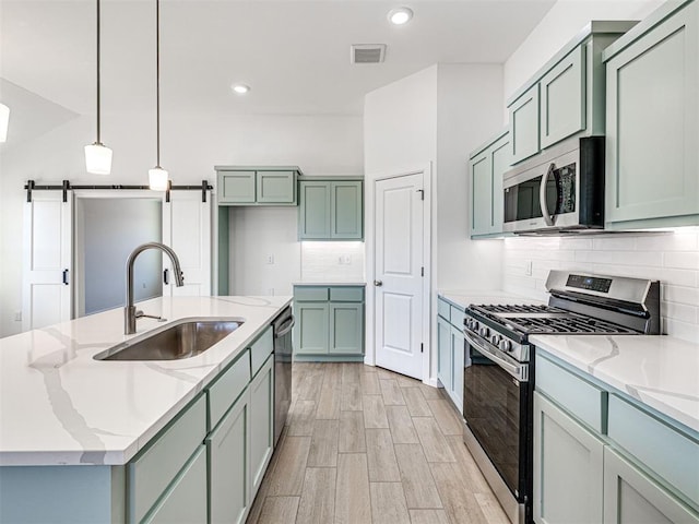 1121 Acacia Creek Dr, Yukon, OK 73099 - kitchen with appliances with stainless steel finishes, a sink, light stone countertops, recessed lighting, and light wood-type flooring