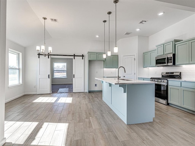 1121 Acacia Creek Dr, Yukon, OK 73099 - kitchen featuring stainless steel appliances, a barn door, a sink, plenty of natural light, and recessed lighting
