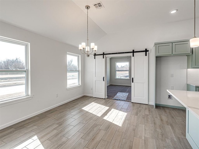 1121 Acacia Creek Dr, Yukon, OK 73099 - unfurnished dining area featuring a barn door, a chandelier, lofted ceiling, light wood-style floors, and baseboards