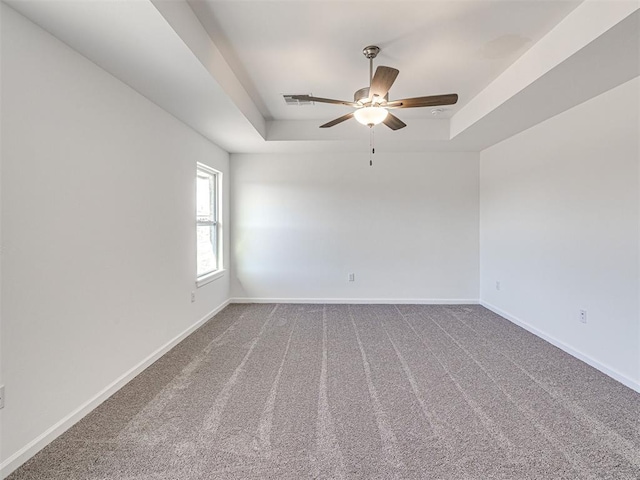 1121 Acacia Creek Dr, Yukon, OK 73099 - carpeted empty room featuring a tray ceiling, a ceiling fan, and baseboards