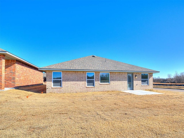 1121 Acacia Creek Dr, Yukon, OK 73099 - back of house featuring brick siding, a patio, a yard, and roof with shingles