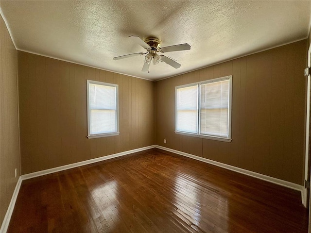 1137 E Chestnut St, Altus, OK 73521 - unfurnished room with dark wood-style flooring, a ceiling fan, a textured ceiling, and baseboards