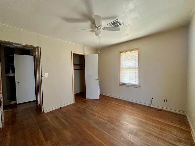 1137 E Chestnut St, Altus, OK 73521 - unfurnished bedroom with dark wood-style flooring, baseboards, a closet, and ceiling fan