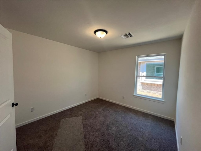 18121 Austin Ct, Edmond, OK 73012 - empty room featuring dark colored carpet and baseboards