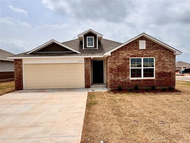 1204 E Stetson Ln, Mustang, OK 73064 - view of front of property with brick siding, driveway, an attached garage, and a shingled roof