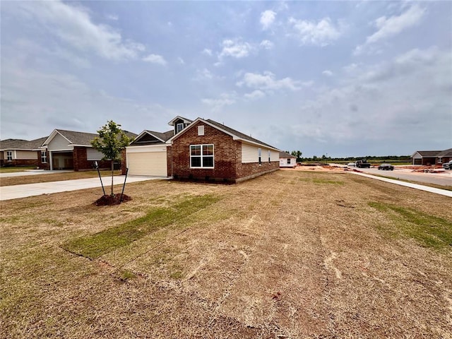 1204 E Stetson Ln, Mustang, OK 73064 - view of front of house with driveway, brick siding, a front yard, and an attached garage