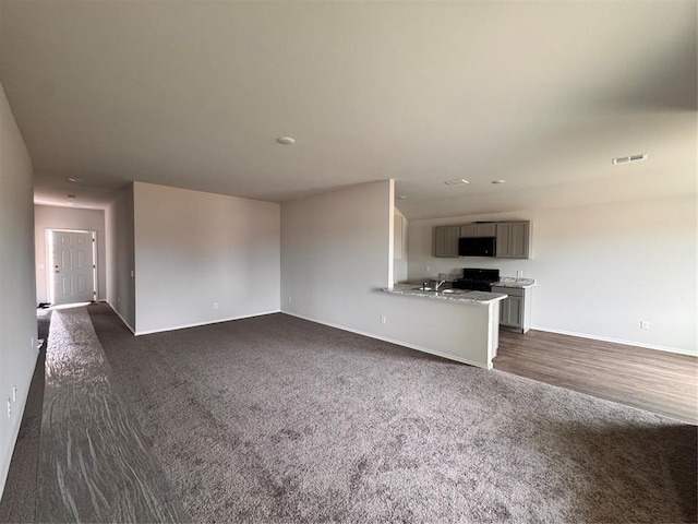 1204 E Stetson Ln, Mustang, OK 73064 - unfurnished living room with dark carpet and baseboards
