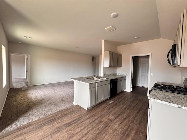 1204 E Stetson Ln, Mustang, OK 73064 - kitchen with dishwasher, baseboards, dark wood finished floors, light stone countertops, and vaulted ceiling