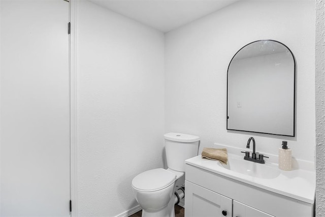 half bathroom with vanity and toilet