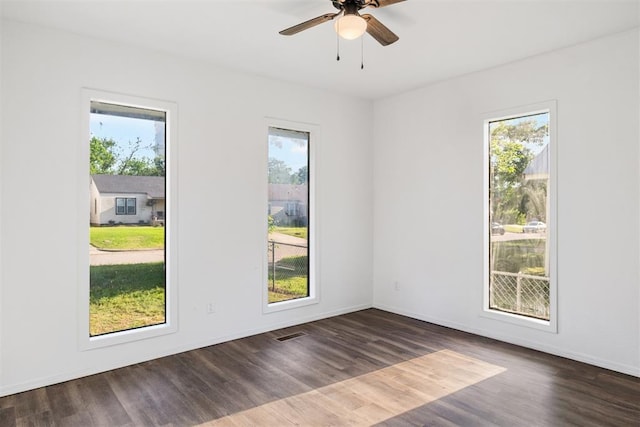 spare room featuring wood finished floors, ceiling fan, and baseboards