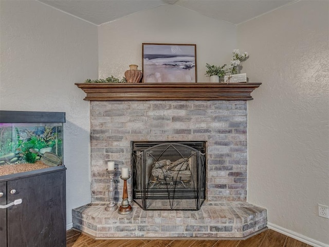 2009 Astoria Dr, Moore, OK 73160 - detailed view of wood finished floors, baseboards, a fireplace, and a textured wall