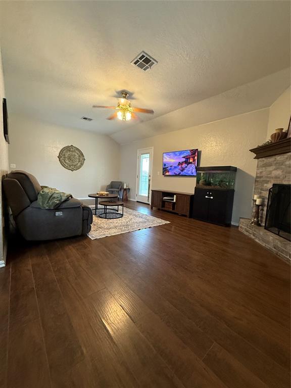 2009 Astoria Dr, Moore, OK 73160 - living area featuring wood finished floors, ceiling fan, a brick fireplace, and lofted ceiling
