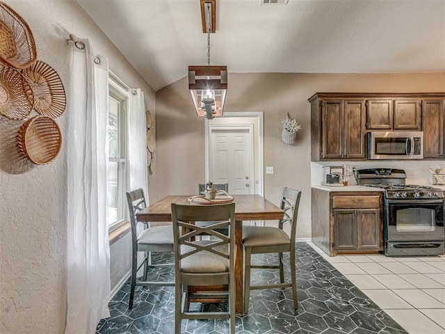 2009 Astoria Dr, Moore, OK 73160 - dining room with lofted ceiling, baseboards, a textured wall, and light tile patterned floors
